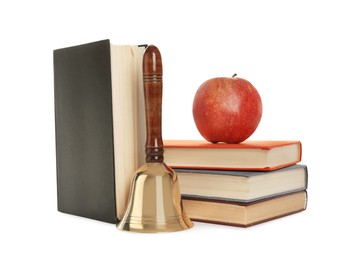Photo of Golden school bell with wooden handle, apple and books on white background