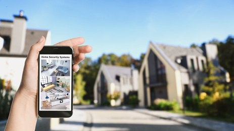 Image of Alarm system. Woman monitoring modern CCTV cameras on smartphone outdoors, space for text