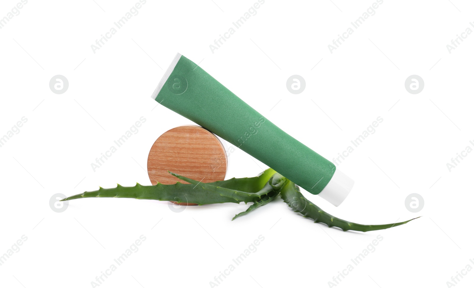 Photo of Tube of toothpaste, aloe vera leaves and wooden decor on white background