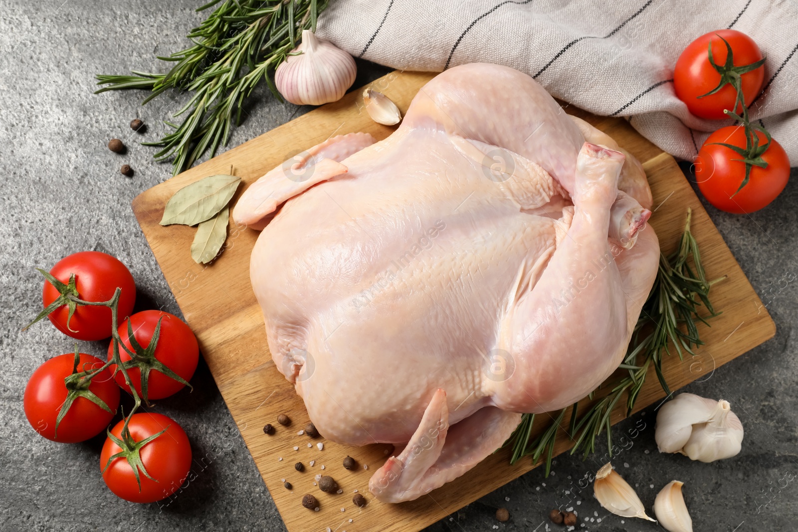 Photo of Fresh raw chicken with spices and vegetables on grey textured table, flat lay