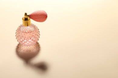 Elegant vintage bottle of perfume on beige background, space for text