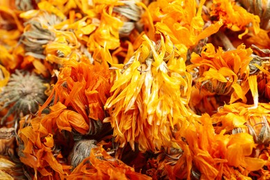 Photo of Pile of dry calendula flowers as background, closeup