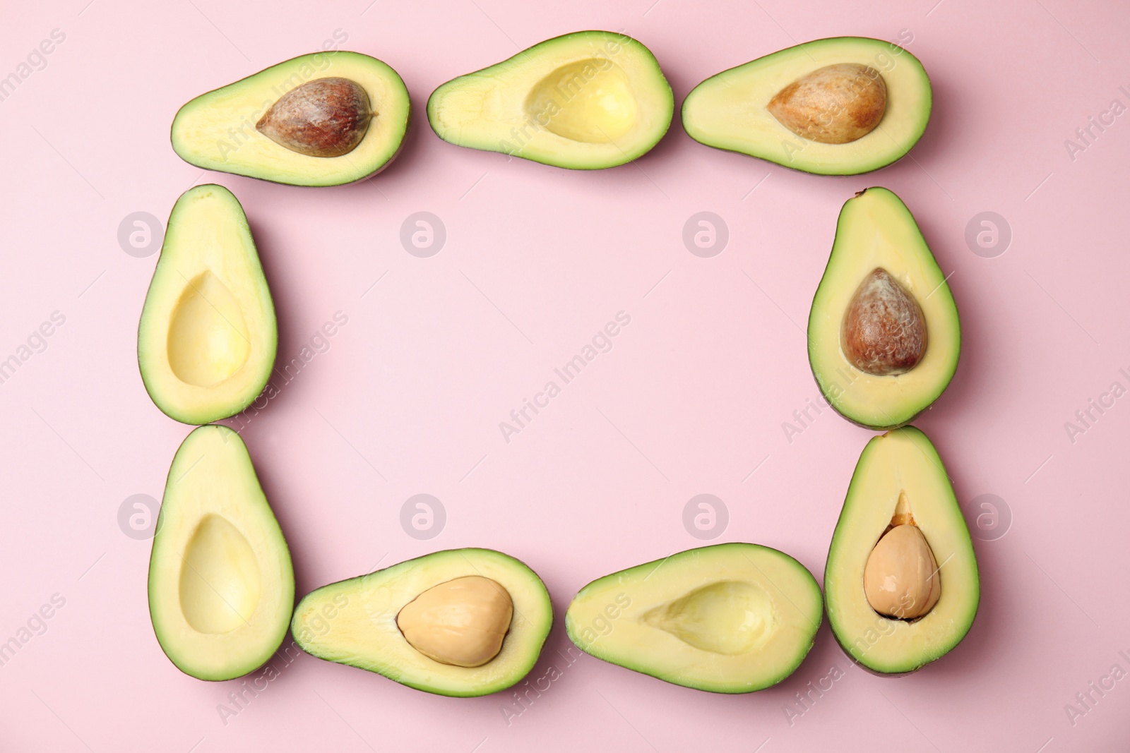 Photo of Frame of cut ripe avocados on pink background, flat lay with space for text