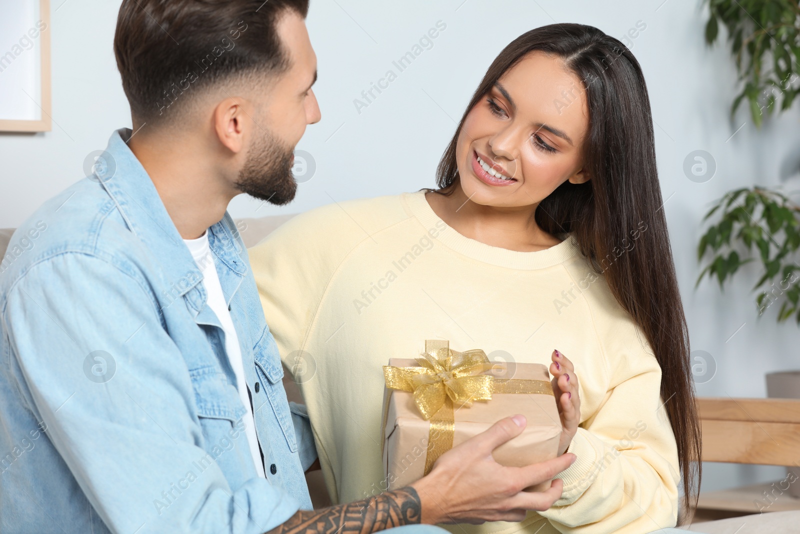 Photo of Lovely couple with beautiful gift at home