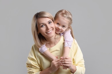 Photo of Family portrait of happy mother and daughter on grey background