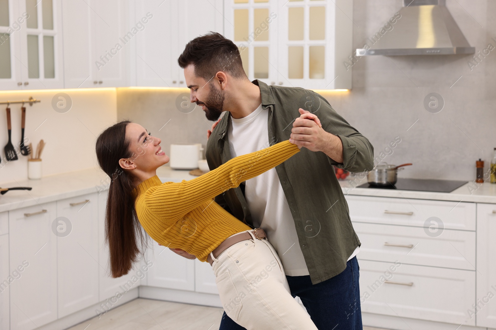 Photo of Happy lovely couple dancing together in kitchen