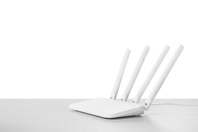 Photo of New modern Wi-Fi router on light grey table against white background. Space for text