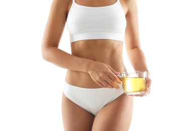 Photo of Young woman holding cup of diet tea on white background, closeup