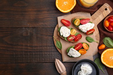 Photo of Delicious sandwiches with burrata cheese and tomatoes served on wooden table, flat lay. Space for text