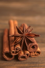 Photo of Cinnamon sticks with anise on wooden table