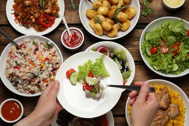 Photo of Woman taking food from buffet table, closeup