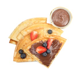 Photo of Tasty crepes with chocolate paste and berries isolated on white, top view
