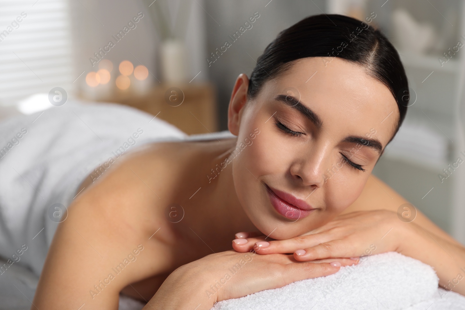 Photo of Beautiful woman relaxing on massage table in spa salon