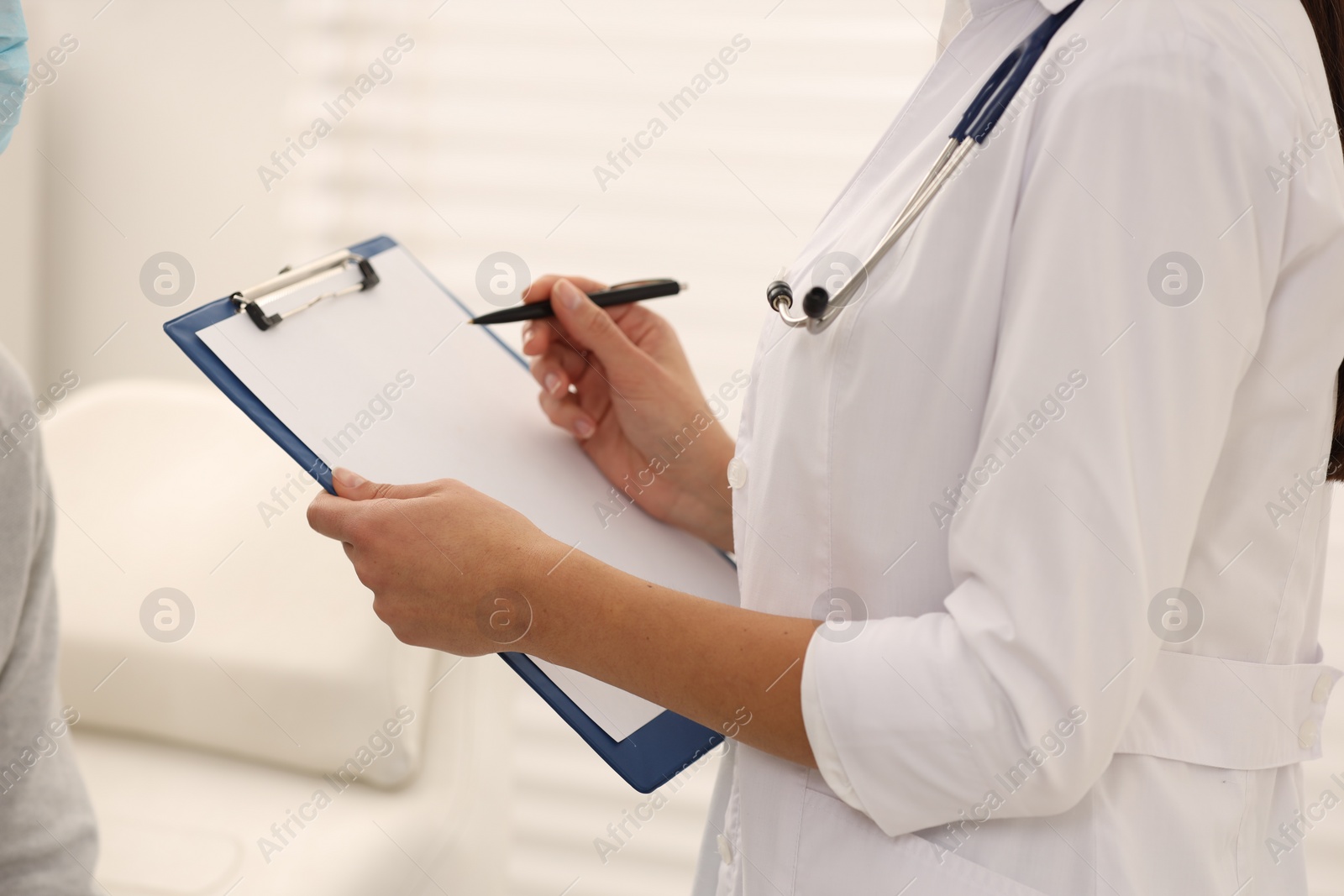 Photo of Nurse with clipboard and pen in hospital, closeup