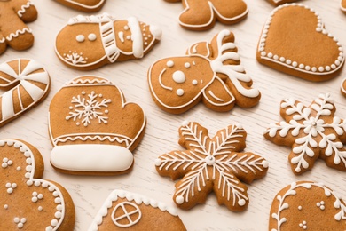 Different Christmas gingerbread cookies on white wooden table, closeup