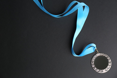 Photo of Silver medal on black background, top view. Space for design
