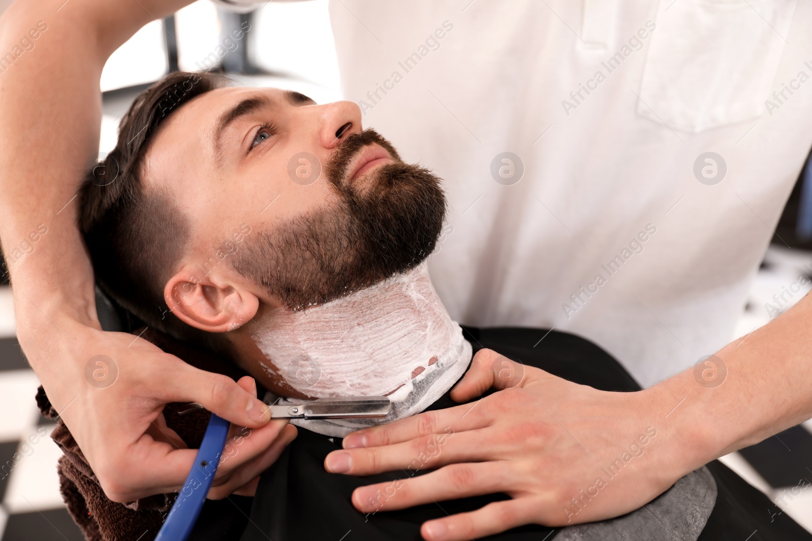 Photo of Professional barber working with client in hairdressing salon. Hipster fashion