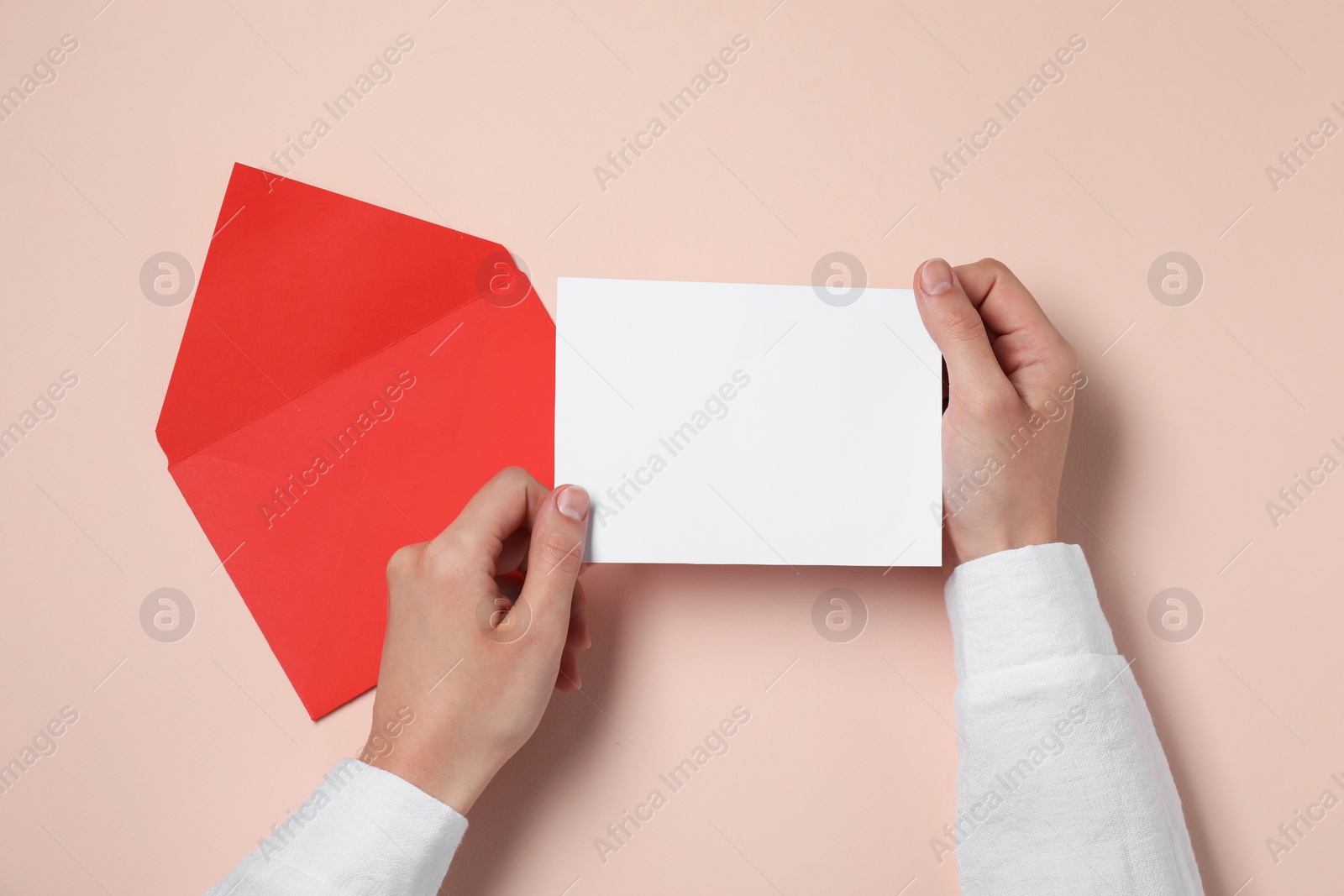 Photo of Woman with blank card at beige table, top view. Space for text