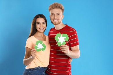 Young couple with recycling symbols on blue background