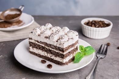 Photo of Plate of delicious tiramisu cake on grey table