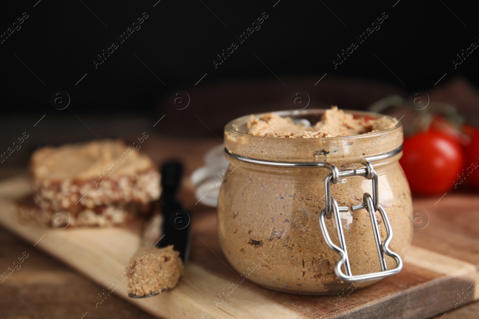 Photo of Delicious meat pate with knife on wooden table, closeup. Space for text