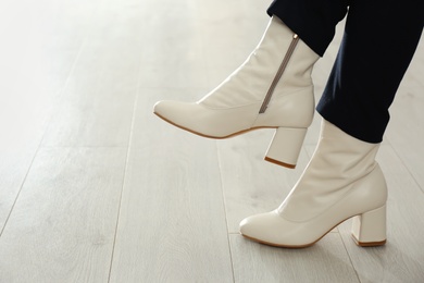 Woman wearing stylish leather shoes indoors, closeup. Space for text