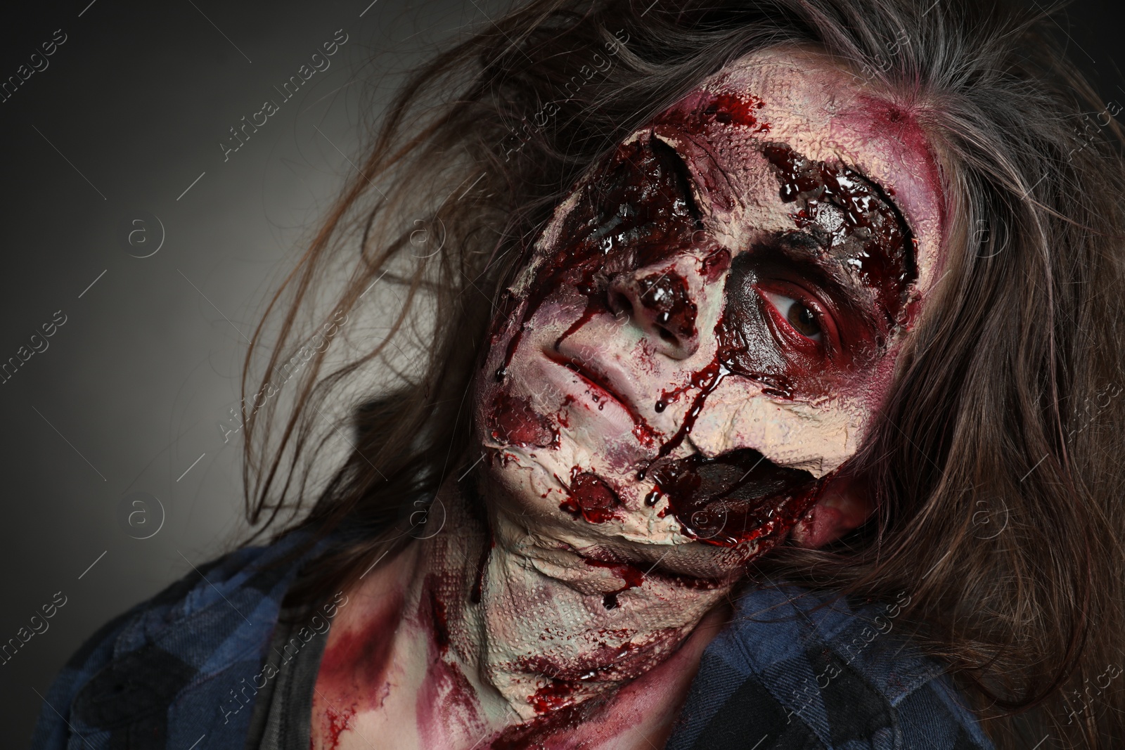 Photo of Scary zombie on dark background, closeup. Halloween monster