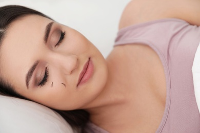 Photo of Young woman with eyelash loss problem sleeping in bed
