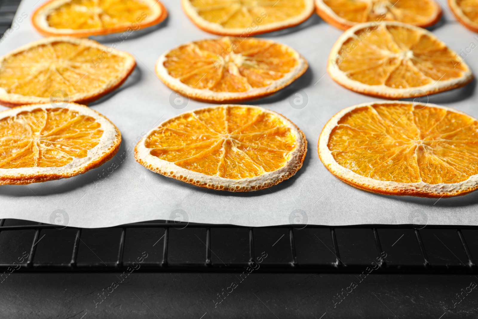 Photo of Dry orange slices on parchment paper, closeup