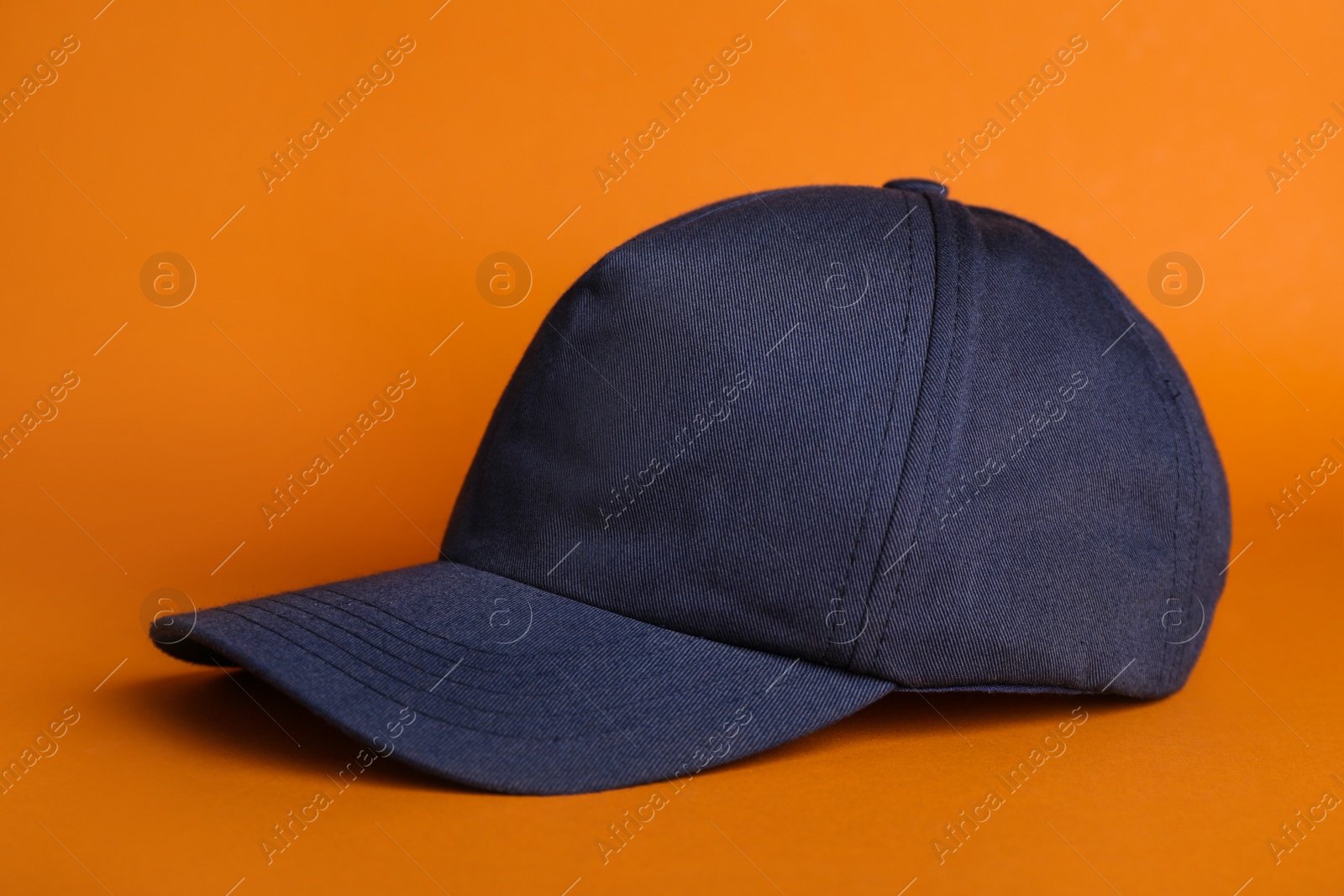 Photo of Baseball cap on orange background. Mock up for design
