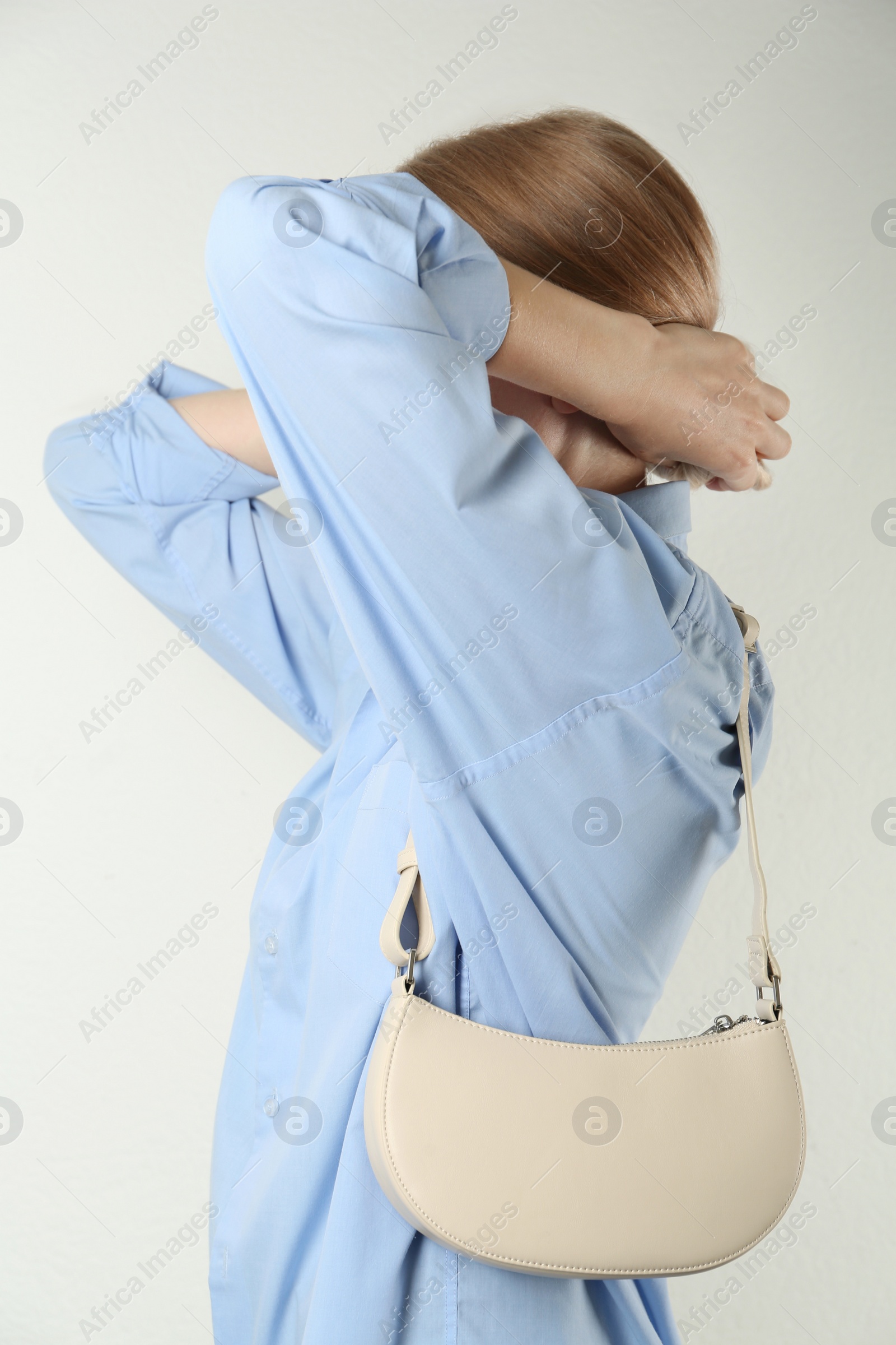 Photo of Woman with stylish baguette handbag on white background