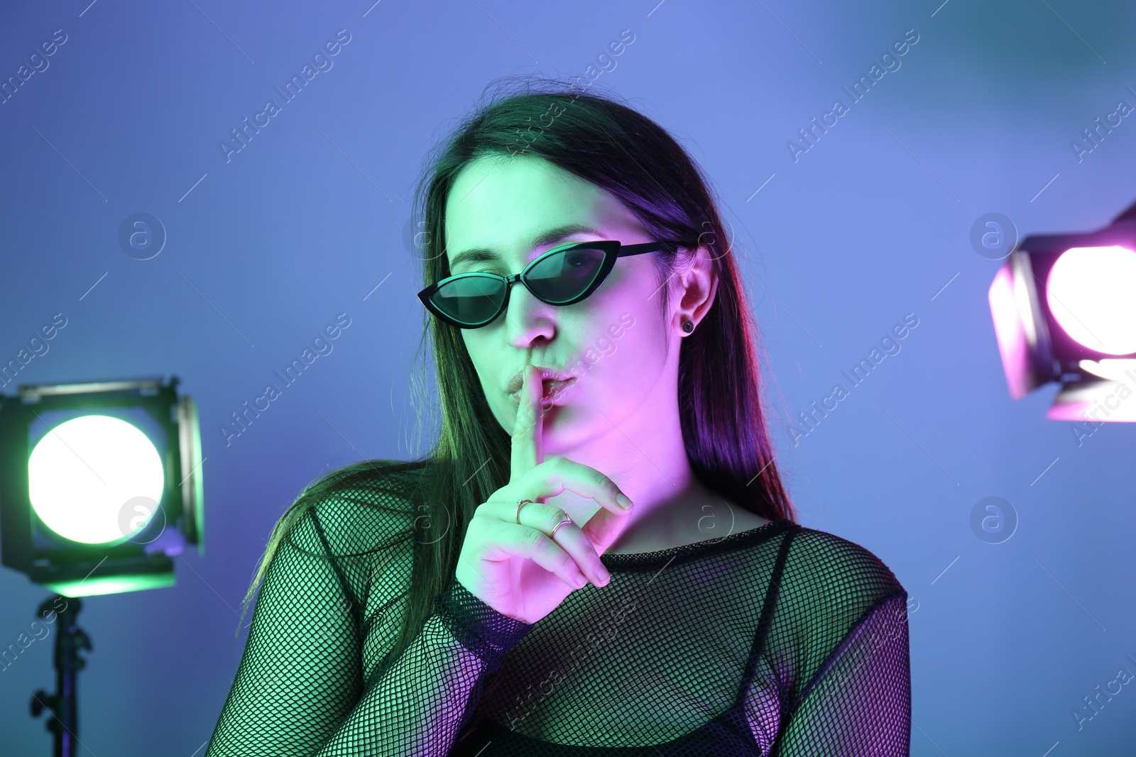 Photo of Portrait of beautiful young woman with sunglasses in photo studio