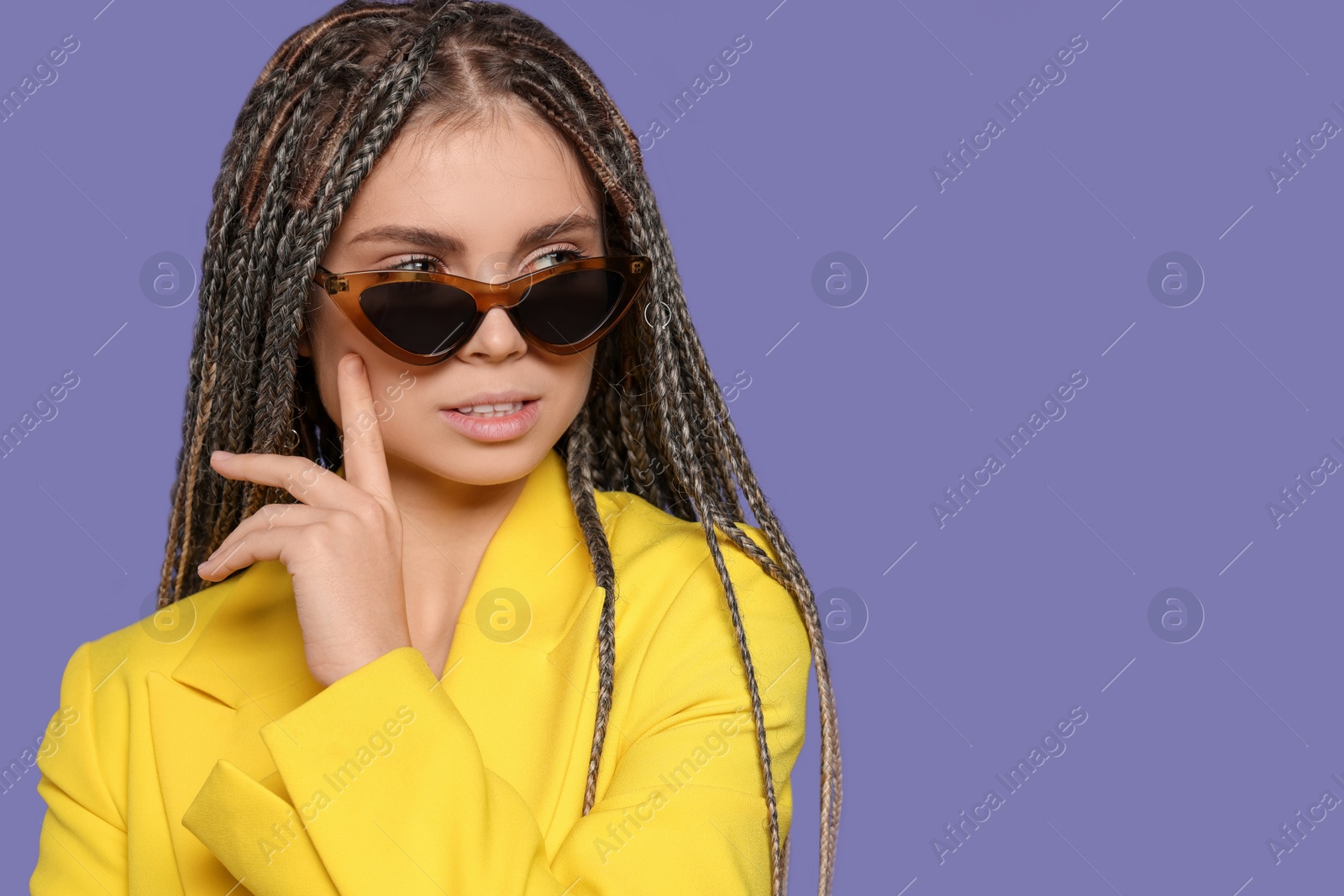 Photo of Beautiful woman with long african braids and sunglasses on purple background, space for text