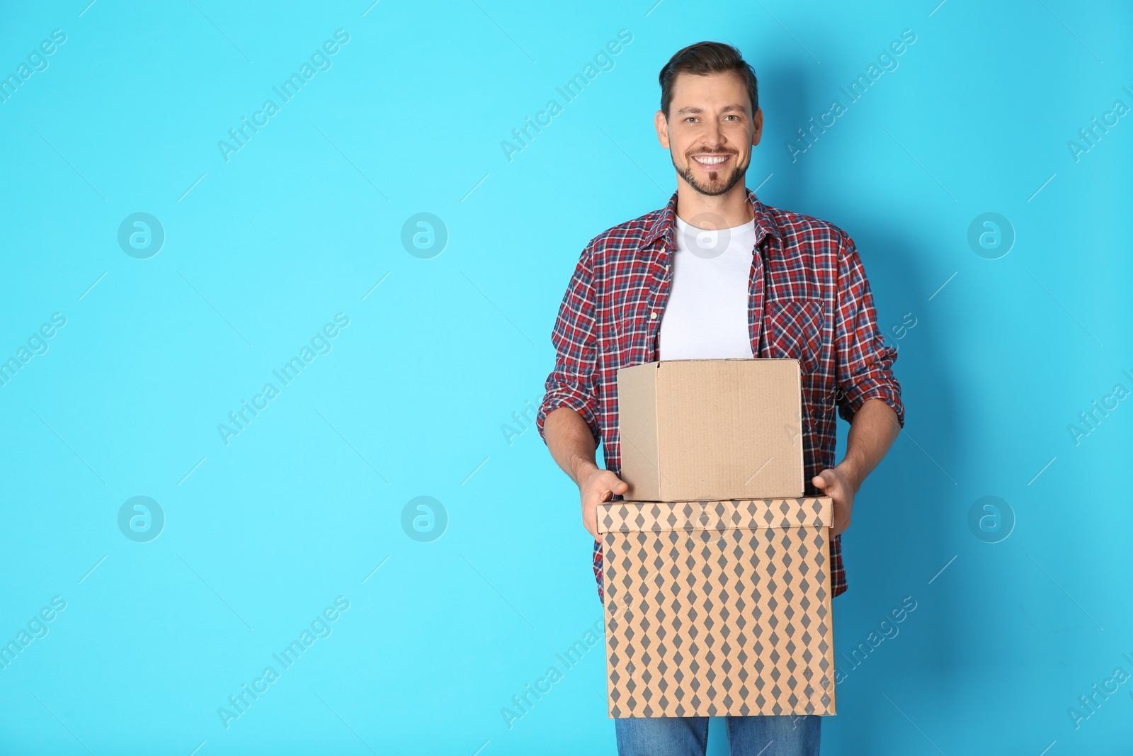 Photo of Man with moving boxes on color background. Space for text