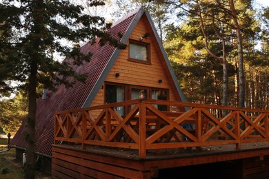 Picturesque view of modern wooden house with veranda in forest