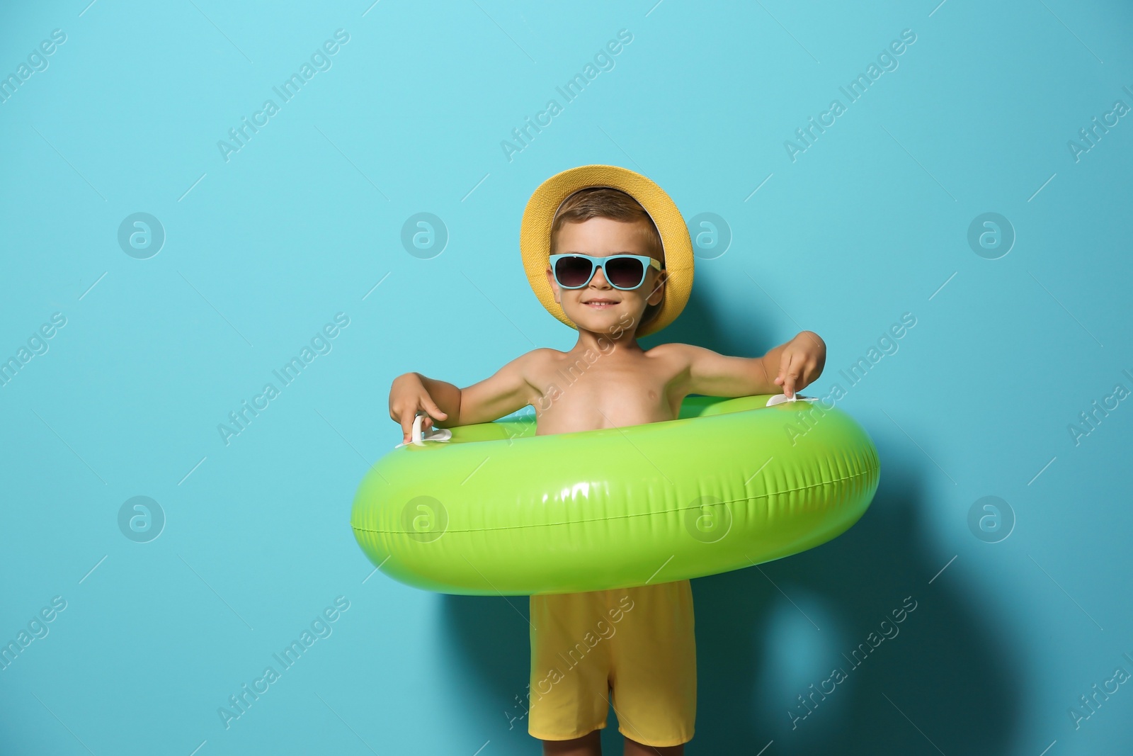 Photo of Cute little boy with inflatable ring on color background