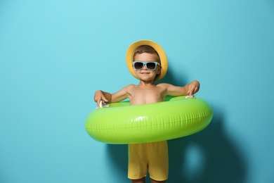 Cute little boy with inflatable ring on color background