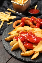 Delicious baked potato and onion rings with ketchup on table, closeup