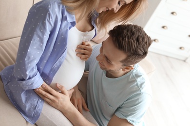 Young pregnant woman with her husband at home