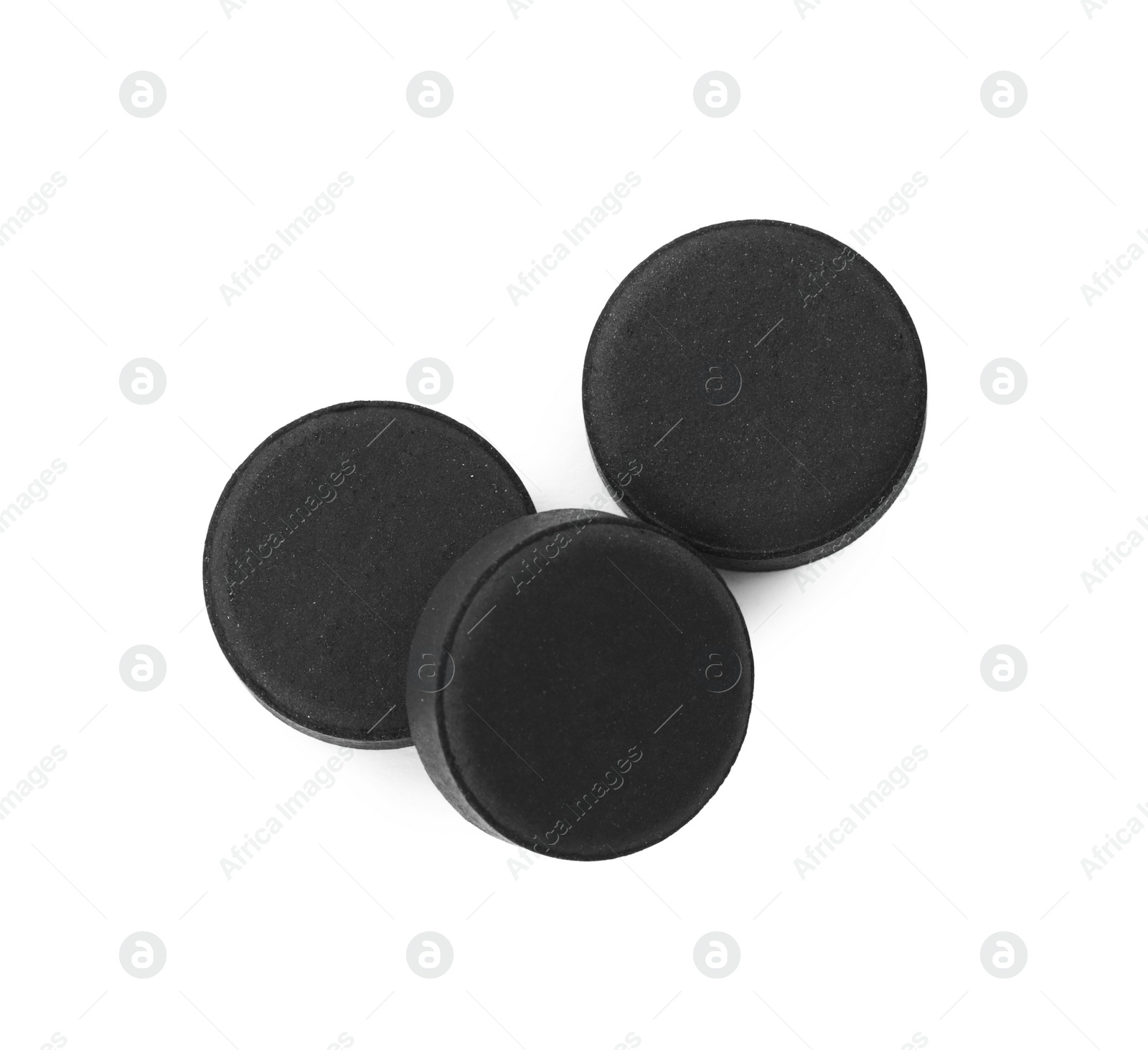 Photo of Activated charcoal pills on white background, top view. Potent sorbent