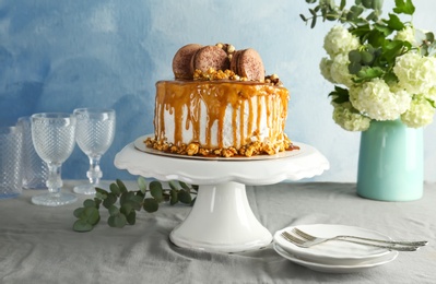 Dessert stand with delicious caramel cake on table