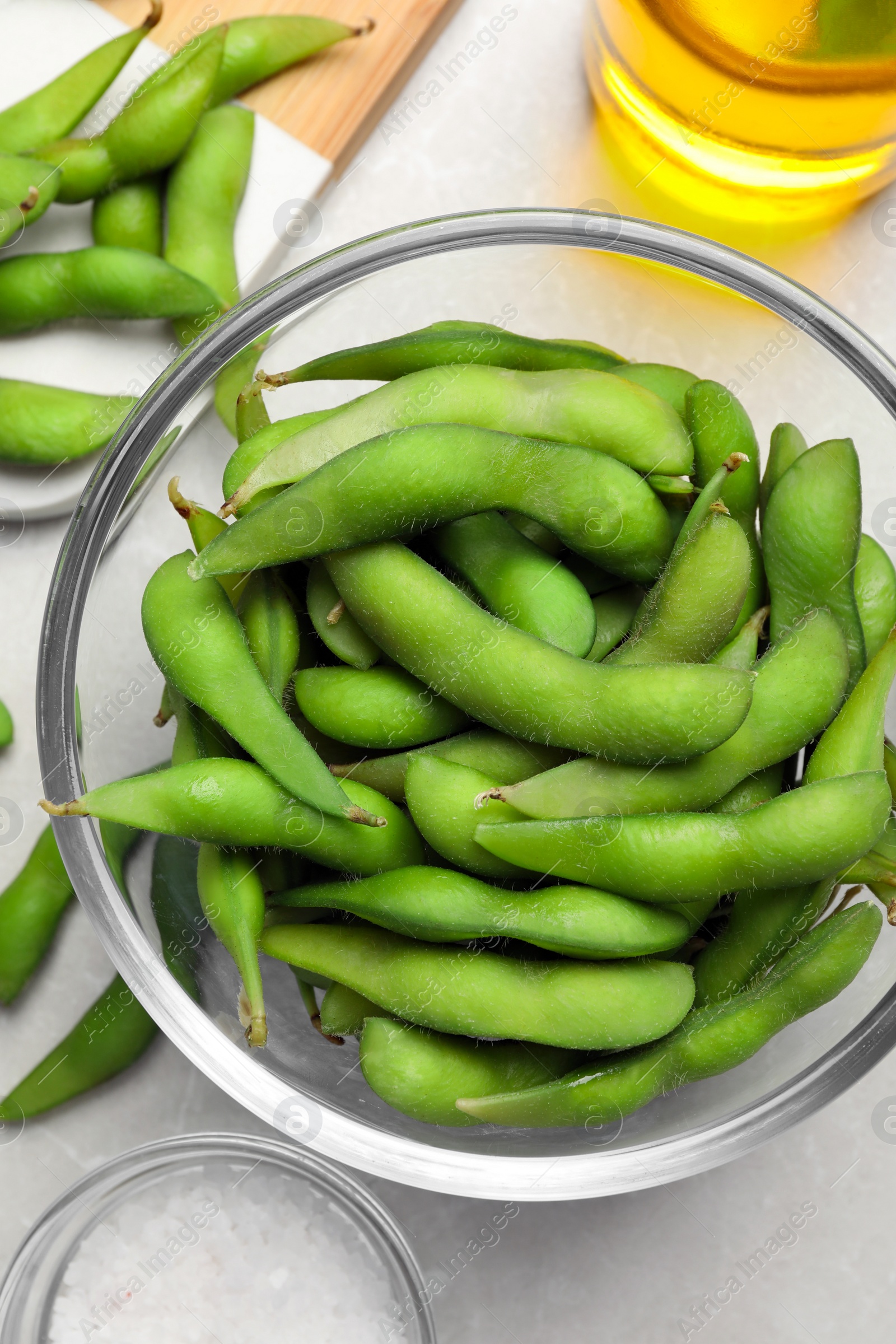 Photo of Green edamame beans in pods served on light grey table, flat lay