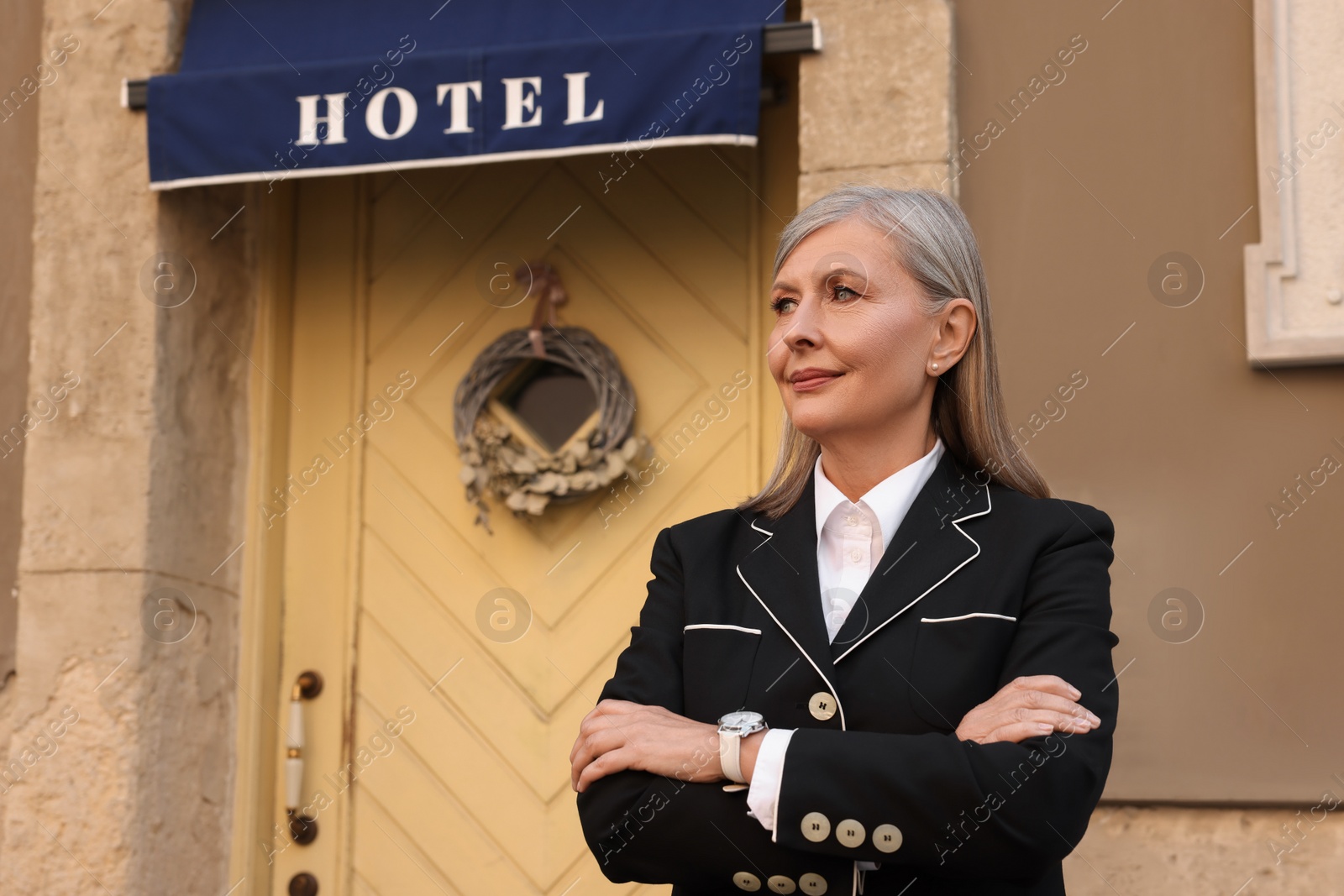 Photo of Portrait of business owner near her hotel outdoors, space for text