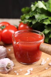 Photo of Delicious ketchup, salt and garlic on table, closeup. Tomato sauce