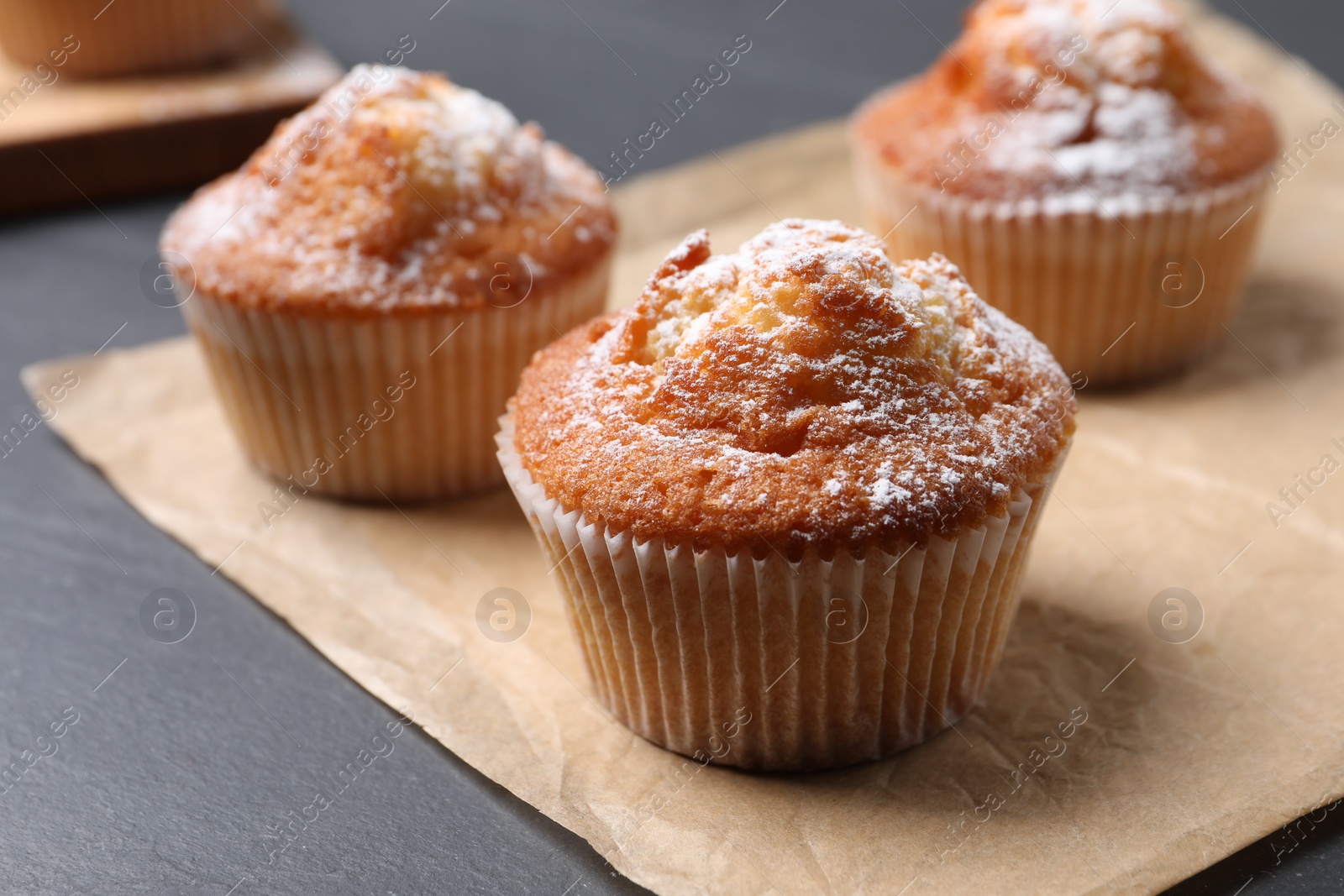 Photo of Delicious sweet muffins on black table, closeup