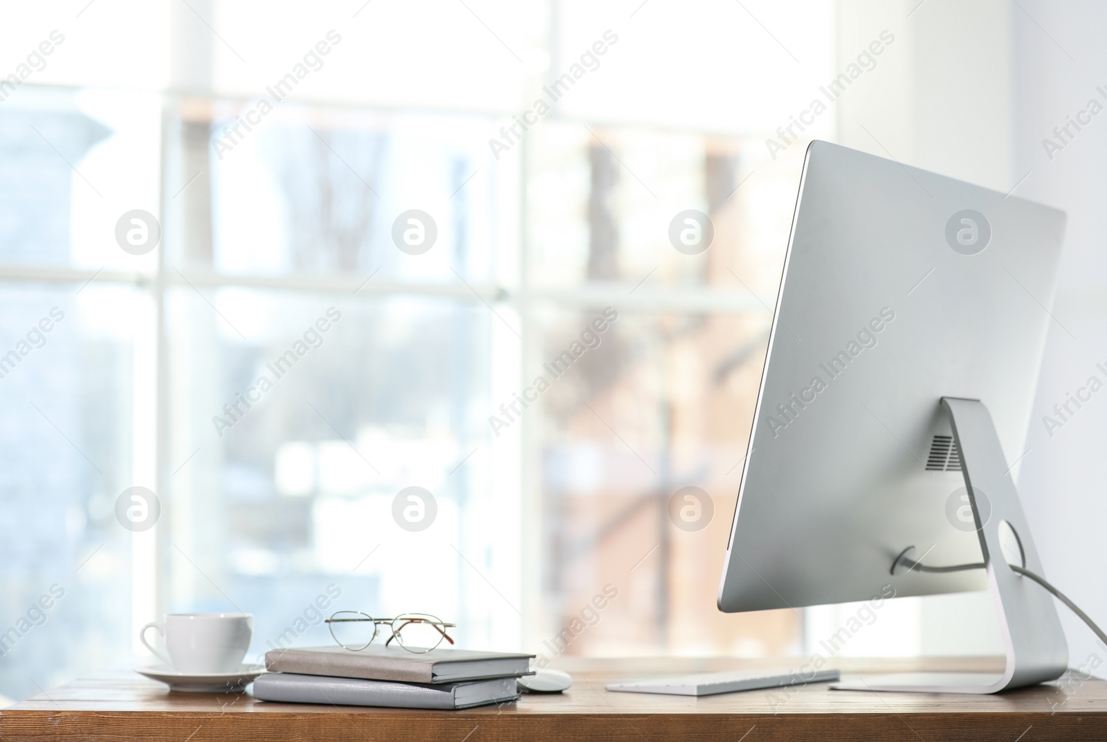 Photo of Computer, notebooks and coffee on table in office