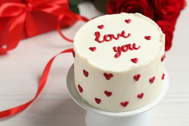 Bento cake with text Love You, gift box and roses on white wooden table, closeup. St. Valentine's day surprise