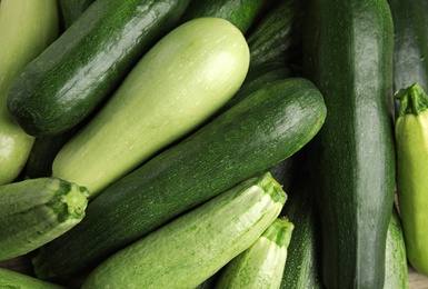 Photo of Top view of fresh ripe zucchini as background, closeup