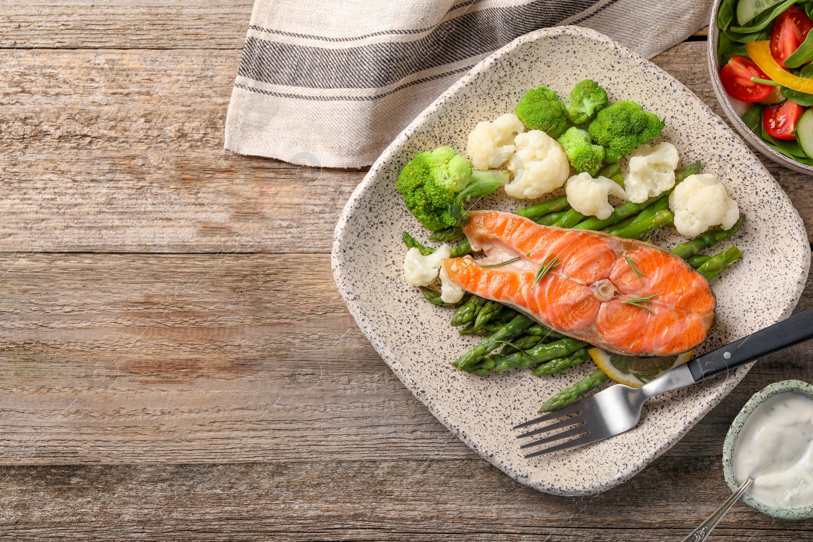 Photo of Healthy meal. Tasty grilled salmon with vegetables served on wooden table, flat lay. Space for text