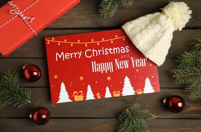 Photo of Flat lay composition with greeting card and Christmas decor on wooden background